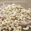 Premium Vietnam W320 cashew nuts arranged in a white bowl, showcasing their perfect crescent shape, uniform size, and flawless pale ivory color required for B2B export.