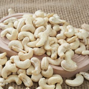 Premium Vietnam W320 cashew nuts arranged in a white bowl, showcasing their perfect crescent shape, uniform size, and flawless pale ivory color required for B2B export.