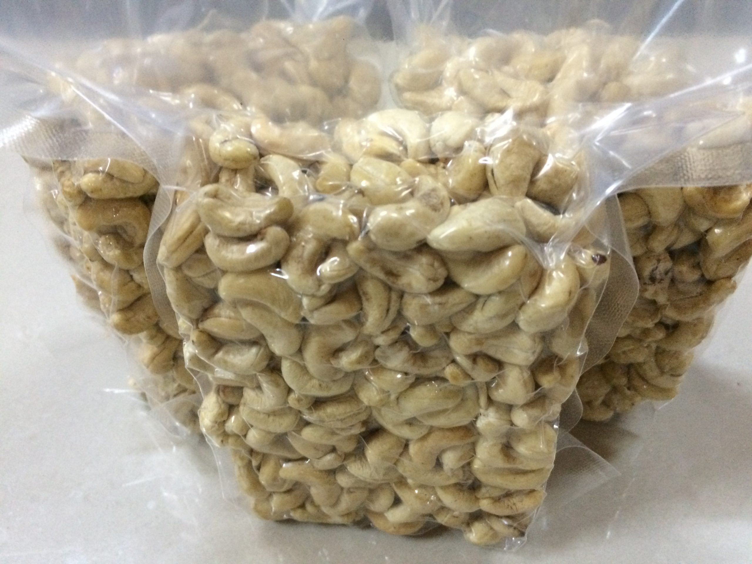 Premium W180 cashew kernels vacuum-sealed in transparent food-grade bags to preserve freshness and crunch.