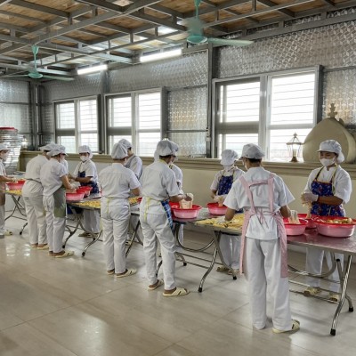 Workers in full protective gear meticulously peeling and cleaning bananas in a highly sterile environment.