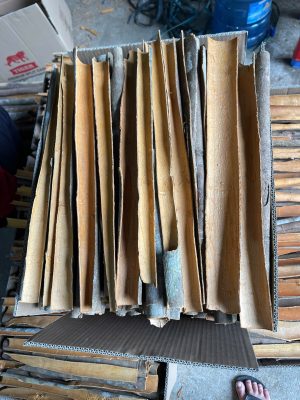 A close-up view of Premium Split Cassia Vietnam showcasing its golden-brown color, perfectly peeled outer bark, and neat arrangement in export cartons.