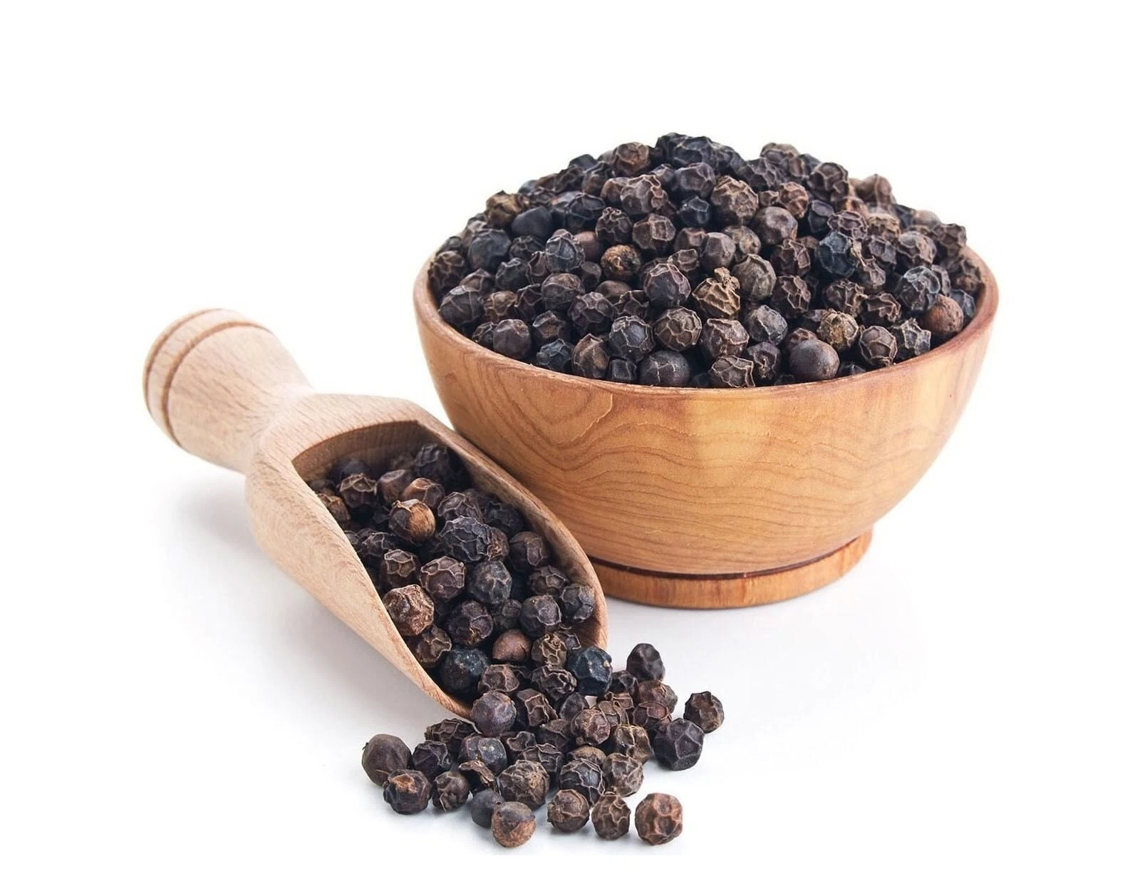 Organic Black Peppercorns overflowing from a wooden bowl and scoop.